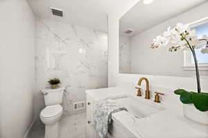 Bathroom featuring vanity and light marble finish floors