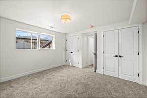 Unfurnished bedroom with multiple closets and carpet flooring