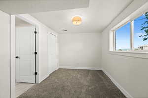 Unfurnished bedroom featuring baseboards and carpet