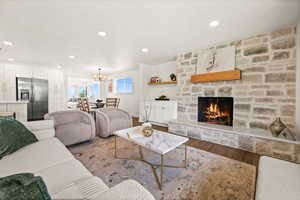Living room featuring a fireplace, wood finished floors, and suspended lighting
