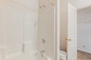 Bathroom featuring tub / shower combination and light wood-style flooring
