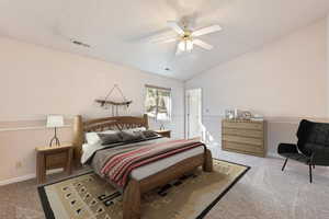Bedroom featuring light colored carpet, lofted ceiling, and ceiling fan