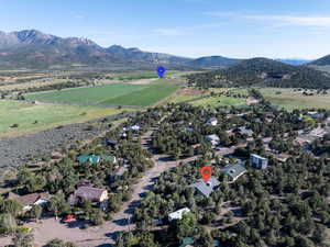 Aerial view of property and surrounding area featuring a mountainous background, nearby suburban area, and rural landscape
