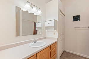 Bathroom featuring vanity, a closet, a shower with curtain, and light wood-style floors