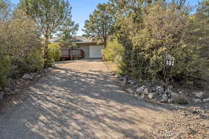 Obstructed view of property with driveway, a deck, and a garage