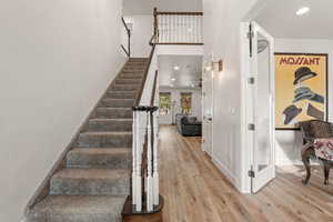 Entrance foyer with recessed lighting, light wood-style flooring, and a high ceiling