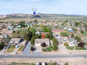 Aerial view of property and surrounding area featuring nearby suburban area and a mountainous background