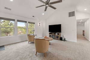 Living area featuring light colored carpet, lofted ceiling, ceiling fan, and recessed lighting