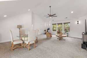 Dining room featuring light carpet, a ceiling fan, recessed lighting, and lofted ceiling