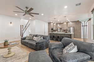Living area featuring light wood finished floors, ceiling fan, and recessed lighting