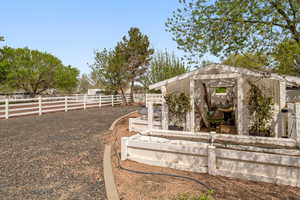 Fenced backyard with an outbuilding, a vegetable garden, and a greenhouse