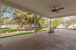Fenced backyard with a patio and ceiling fan
