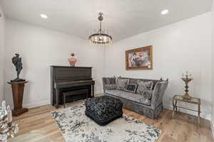 Living room with light wood-style floors and suspended lighting