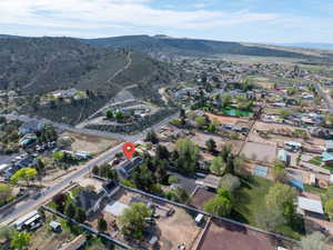 Aerial overview of property's location featuring a mountain backdrop and nearby suburban area