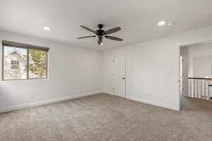 Empty room featuring carpet, ceiling fan, and recessed lighting