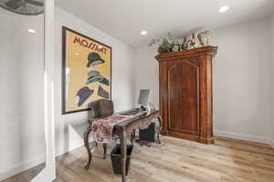Office area featuring light wood-style floors and recessed lighting