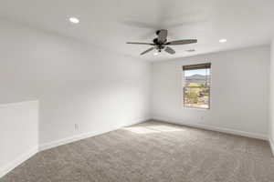 Carpeted spare room with a mountain view, a ceiling fan, and recessed lighting