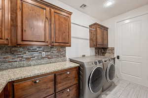 Laundry room with cabinet space, washing machine and dryer, and a textured ceiling