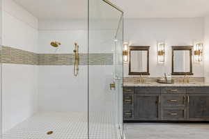 Bathroom featuring double vanity and a shower stall