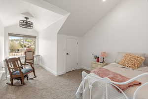 Bedroom featuring lofted ceiling and light colored carpet