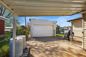 Detached garage featuring a gate and driveway