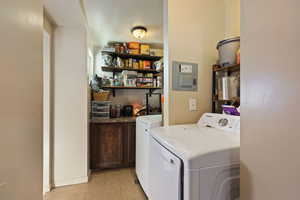 Laundry area featuring light tile patterned floors and washing machine and clothes dryer