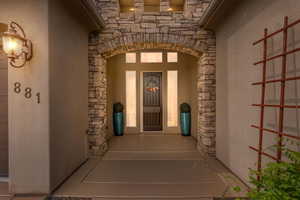 Property entrance featuring stone siding and stucco siding