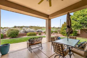 Fenced backyard with outdoor dining area, a patio, and ceiling fan
