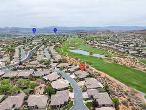 Aerial view of property and surrounding area featuring a water and mountain view, nearby suburban area, and a golf club