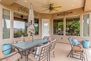 View of patio with outdoor dining area and ceiling fan