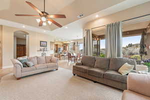 Living room featuring a ceiling fan, recessed lighting, and arched walkways