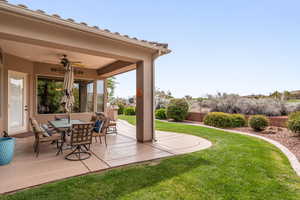 Fenced backyard with a ceiling fan, a patio, and outdoor dining area