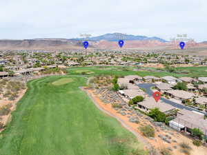 Aerial view of residential area with a golf course and a mountainous background
