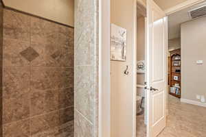 Full bath with toilet and a shower stall