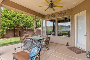 Fenced backyard with outdoor dining area, a ceiling fan, and a patio