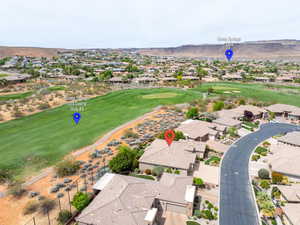 Aerial view of residential area featuring a golf course and a mountain backdrop
