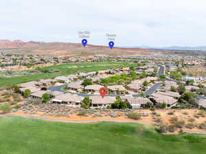 Aerial perspective of suburban area featuring a mountainous background and a golf club