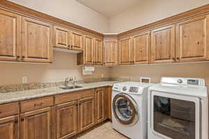 Laundry area with cabinet space, separate washer and dryer, and light tile patterned flooring