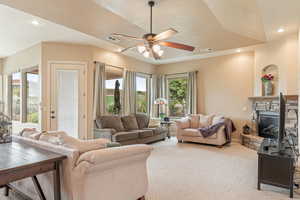 Living area with recessed lighting, light carpet, ceiling fan, a fireplace, and a textured ceiling