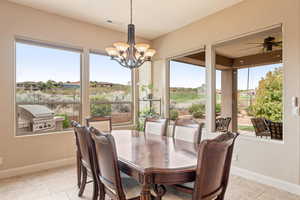 Dining room featuring plenty of natural light, light tile patterned floors, a chandelier, and a ceiling fan
