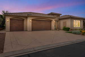 Mediterranean / spanish house with stucco siding, a garage, and concrete driveway