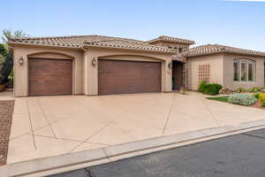 Mediterranean / spanish home with stucco siding, a garage, and driveway