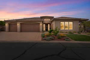 Mediterranean / spanish house featuring a garage, stucco siding, concrete driveway, and a tiled roof