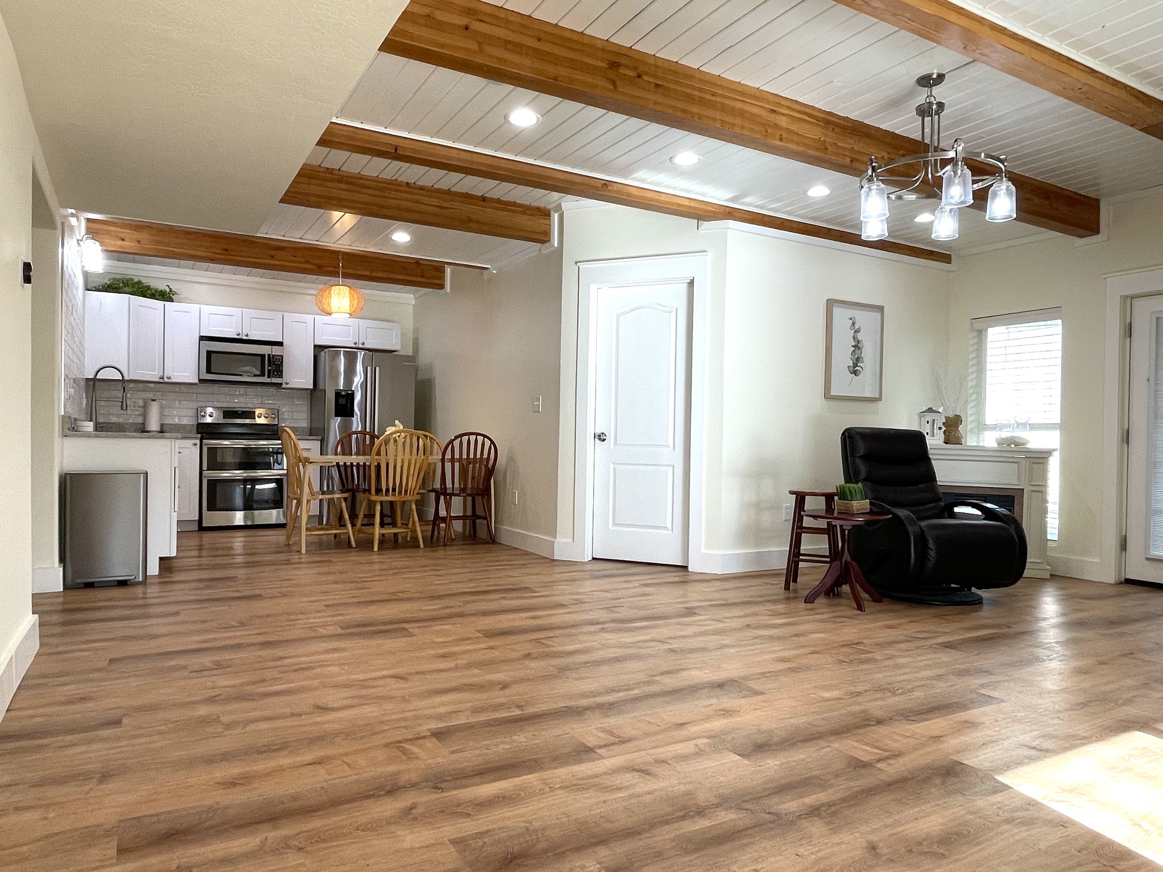 Living area with a wooden ceiling with exposed beams, dark wood finished floors, and suspended lighting