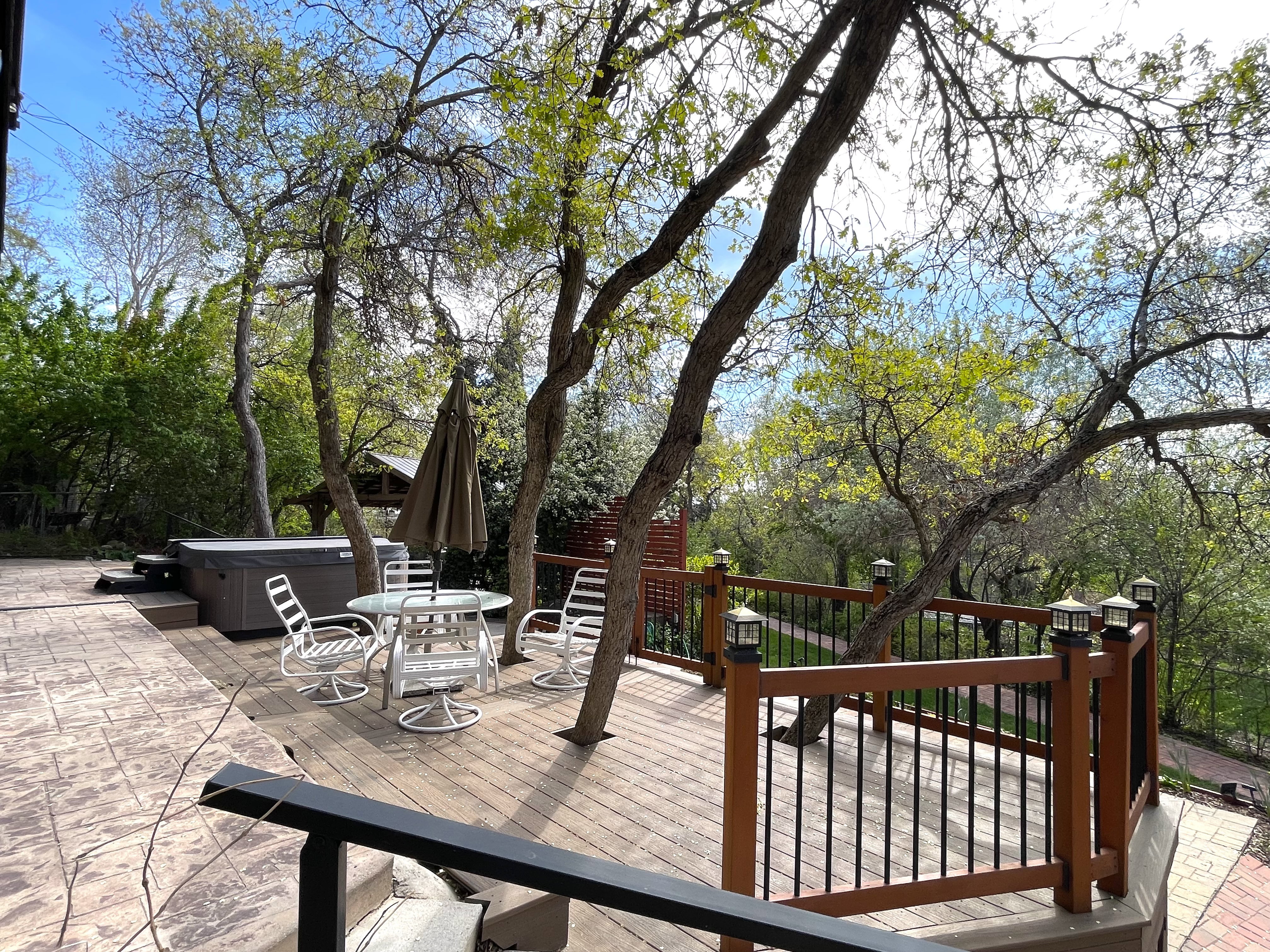 Wooden deck with outdoor dining area and a hot tub