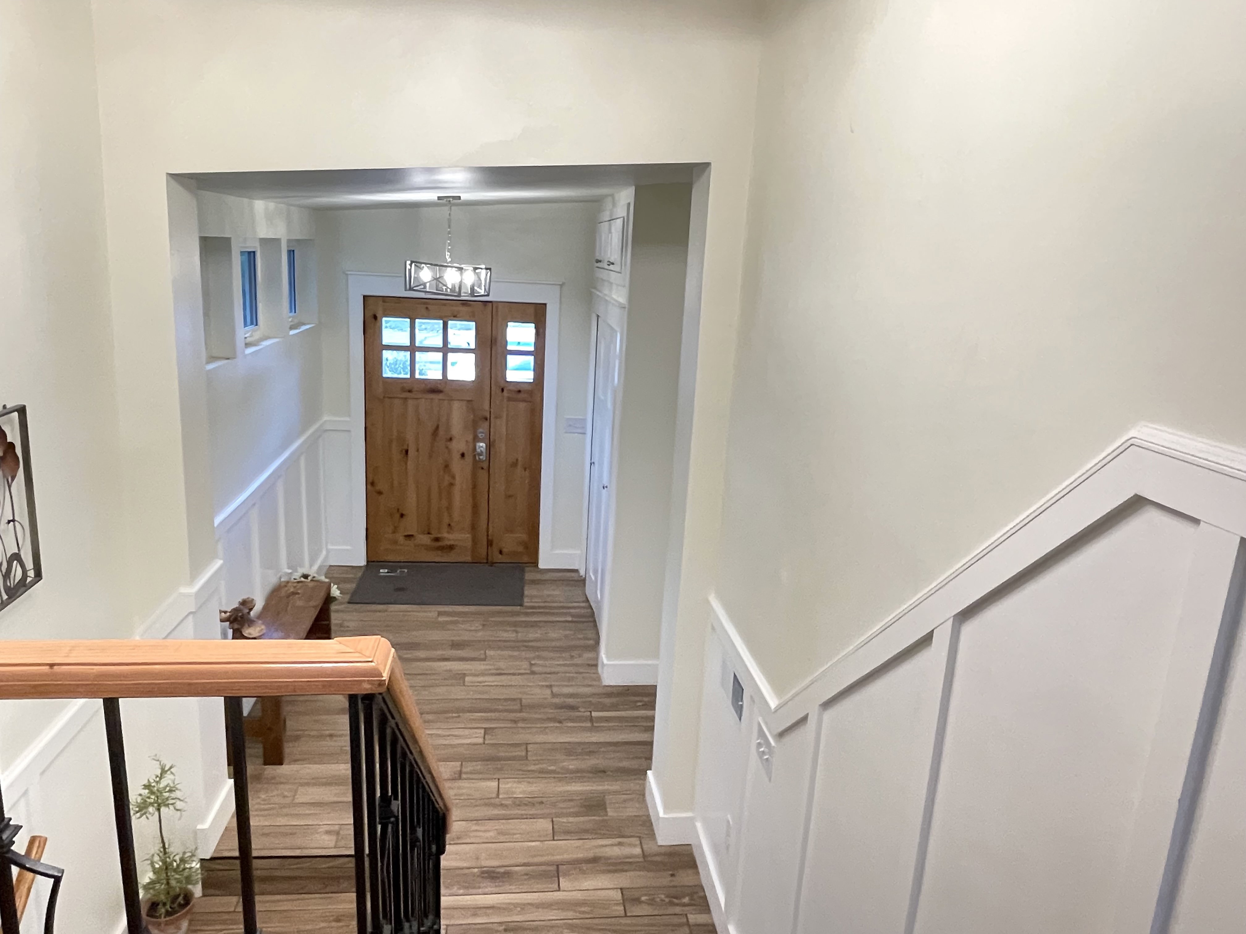 Entryway featuring a decorative wall, a wainscoted wall, and wood finished floors