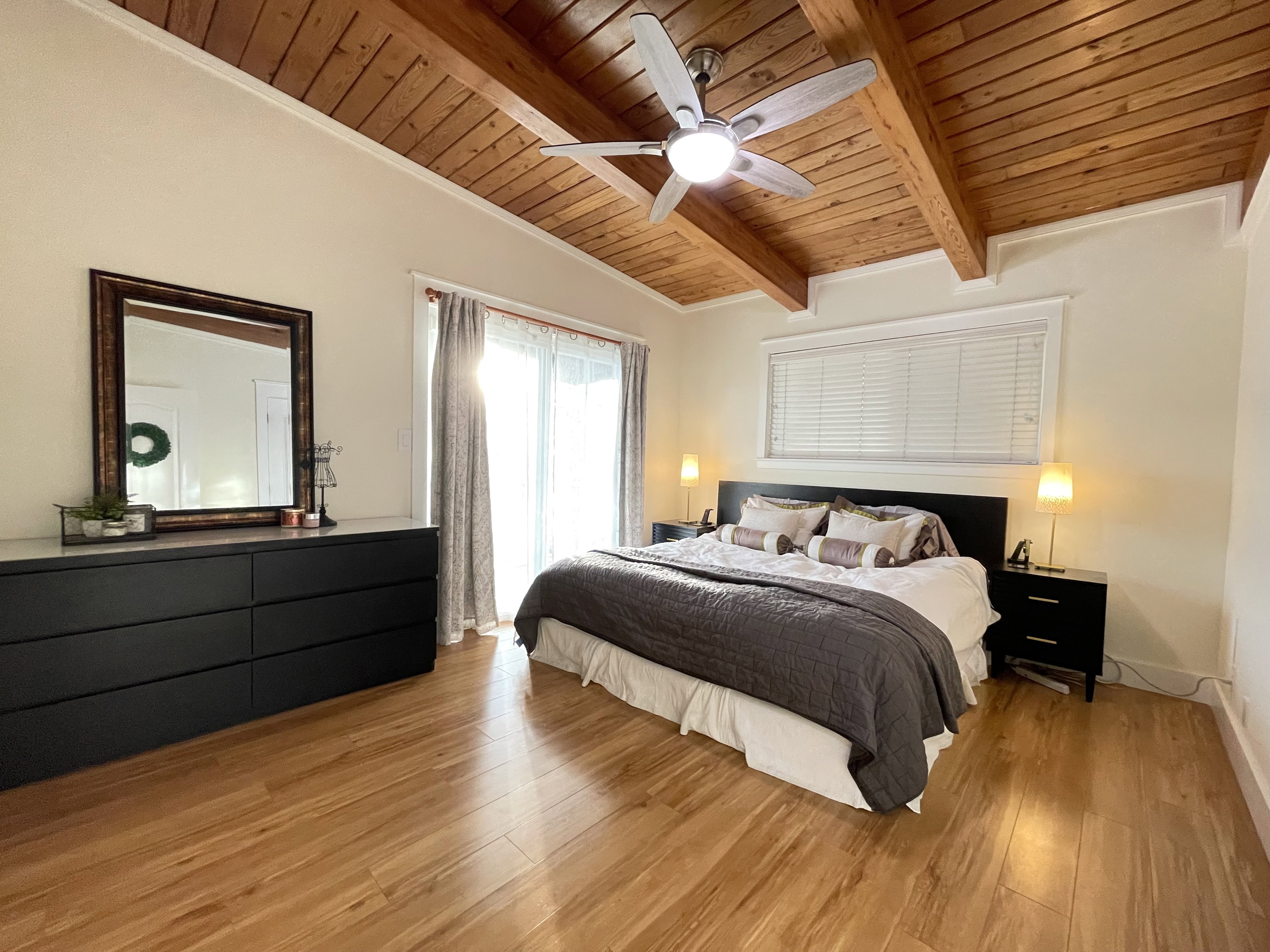 Bedroom featuring light wood-style floors, a wood ceiling with exposed beams, and ceiling fan