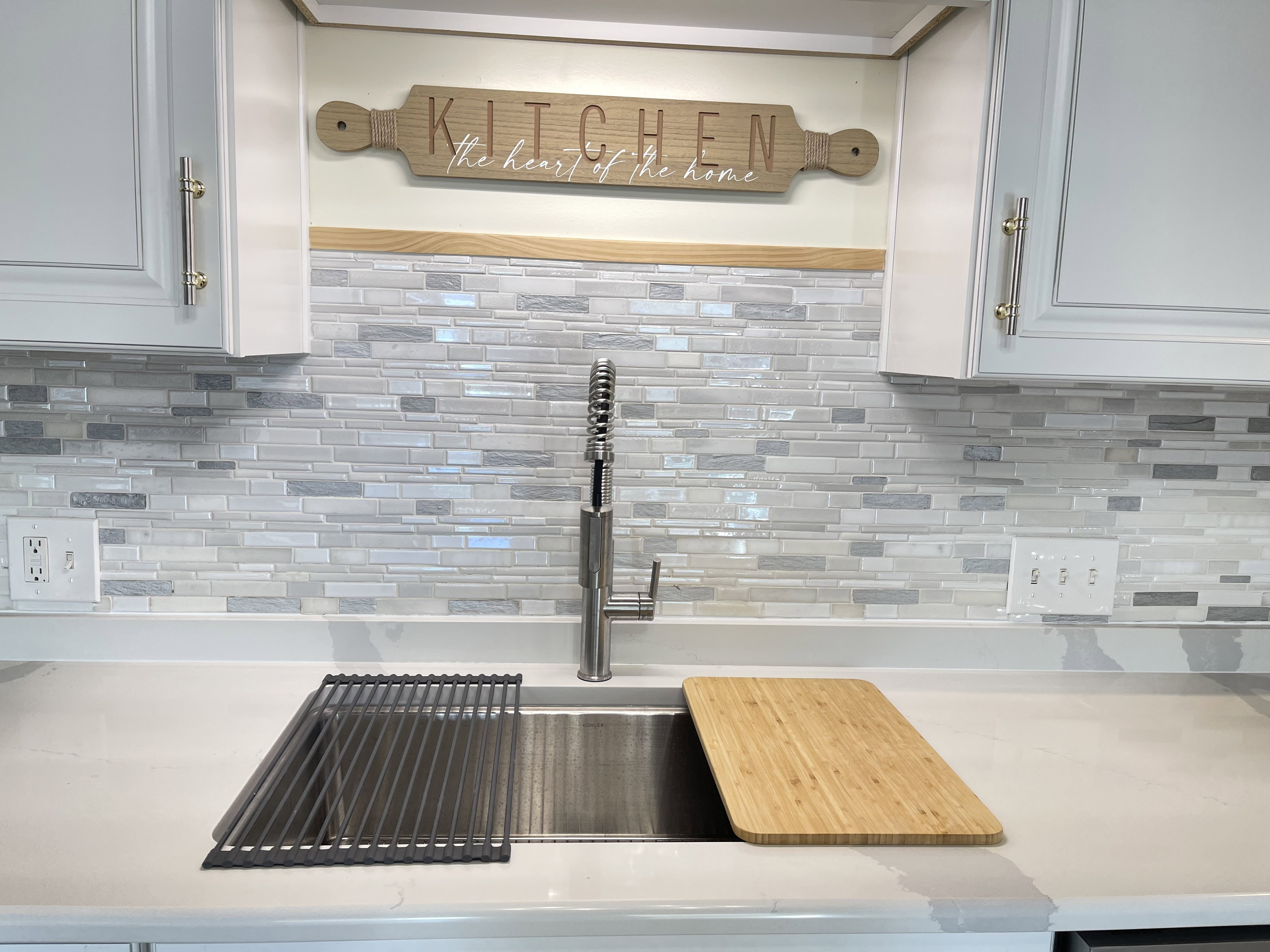 Kitchen view of white cabinetry, light stone counters, and decorative backsplash