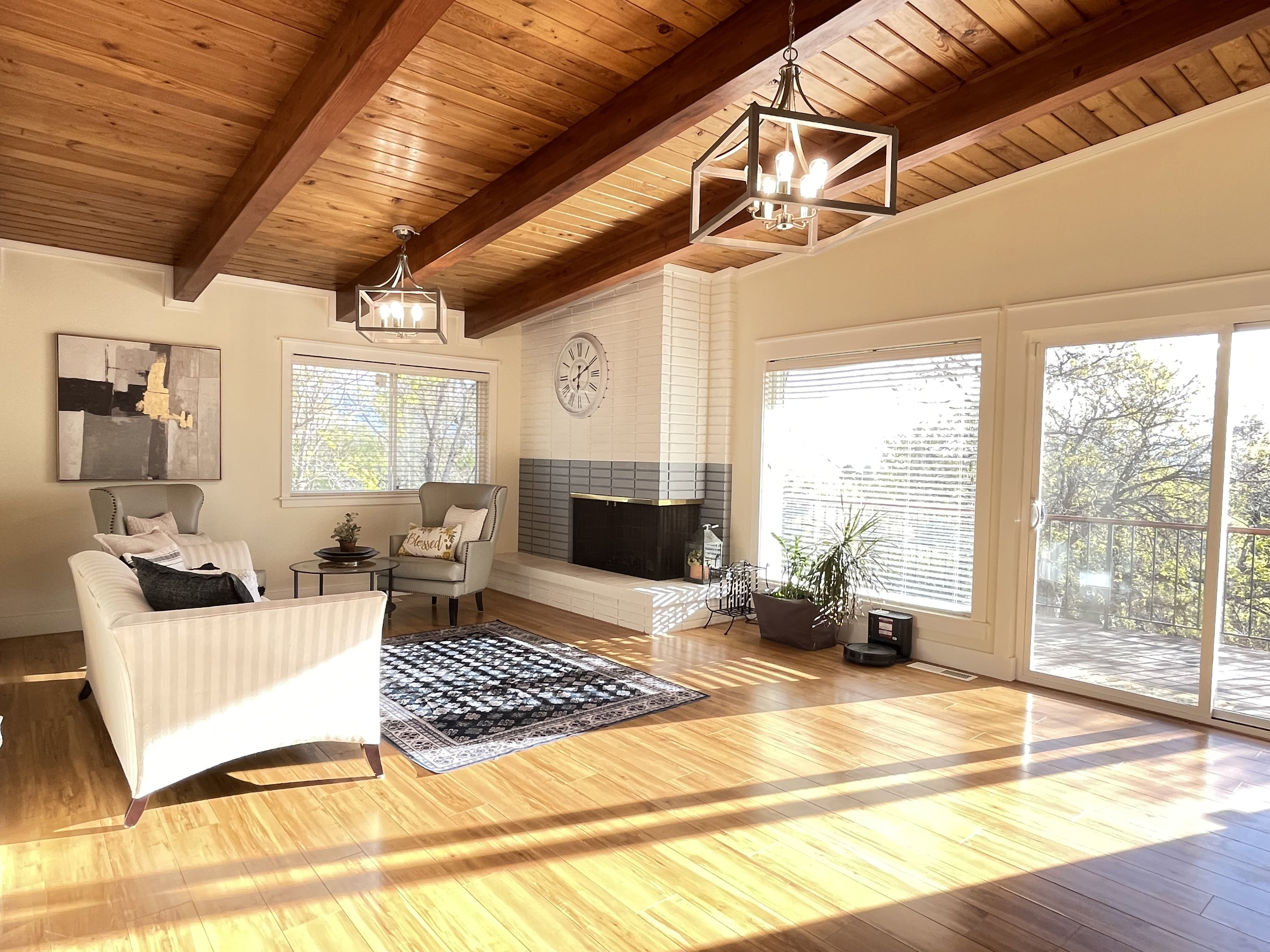 Living area featuring a chandelier, a fireplace, wood finished floors, wood ceiling, and lofted ceiling with beams
