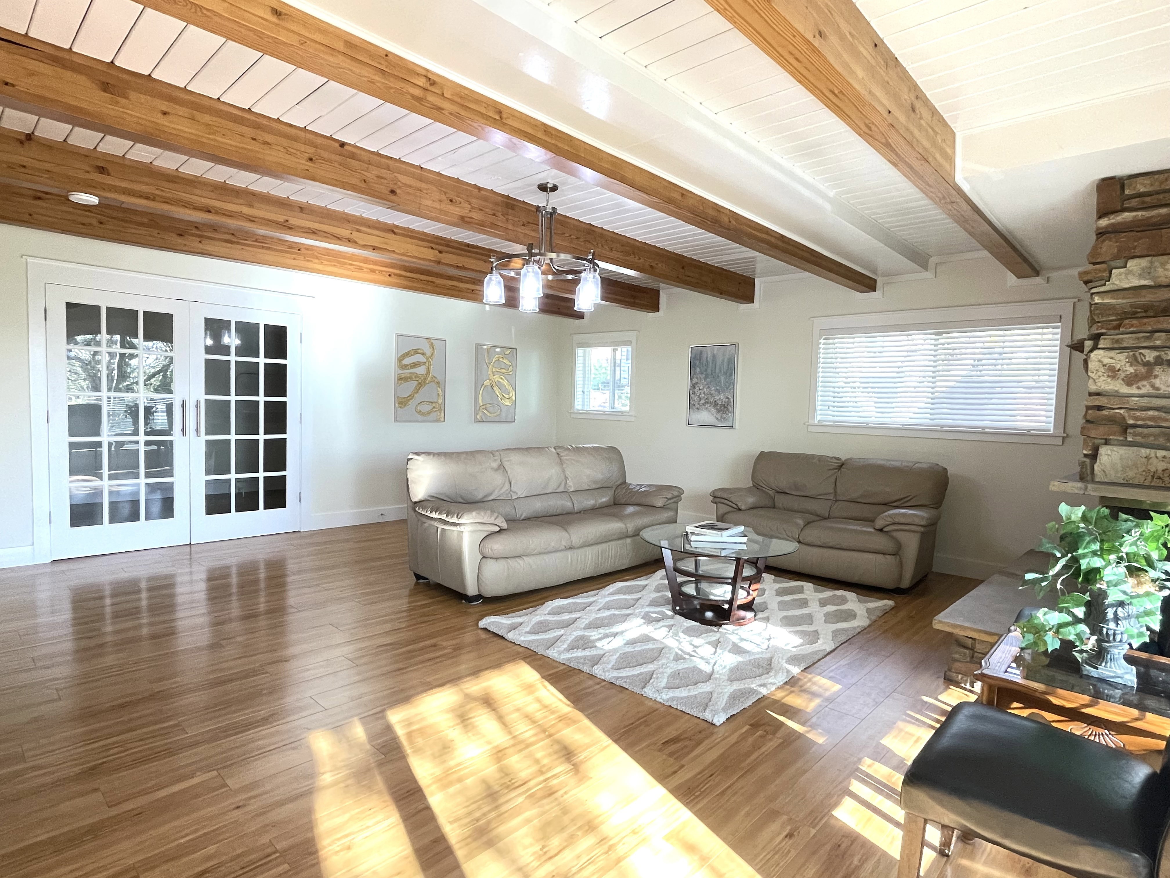 Living room featuring hardwood / wood-style flooring and a wooden ceiling with exposed beams